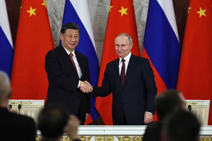 Kinas president Xi Jinping og Vladimir Putin tar hverandre i hånden i Moskva 1. mars 2023