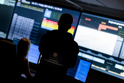 To personer står og følger med på skjermer i Nasjonalt cybersikkerhetssenter, som overvåker digitale hendelser i Norge.